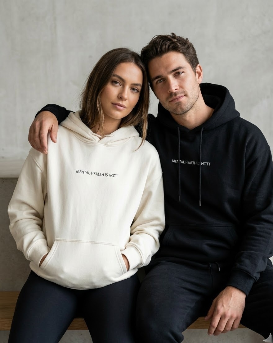 Couple seated — cream and black hoodies